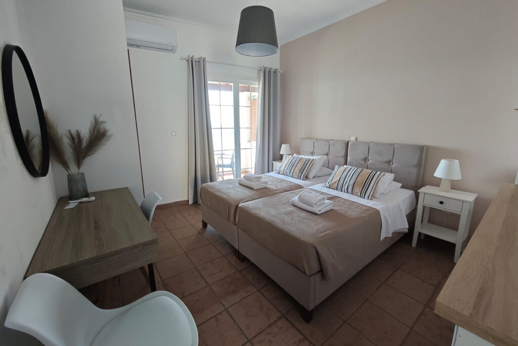 Two large beds next to each other with white towels on top in Cymatologe studio.