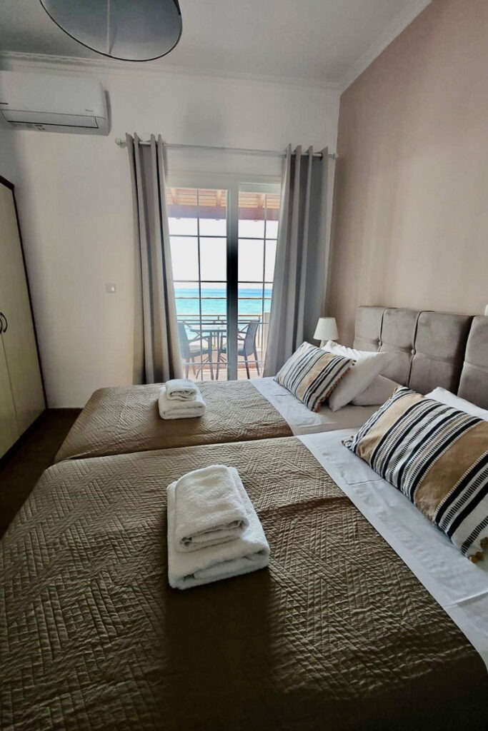 Two large beds next to each other with white towels on top in Cymatologe studio.