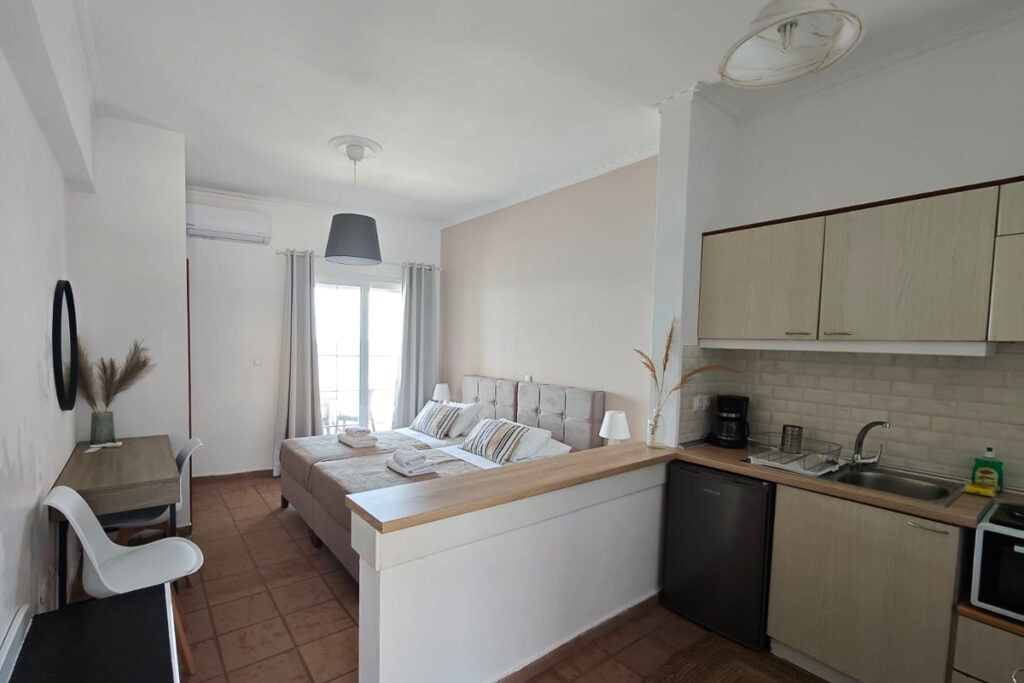 Cymatolege's kitchen area and two large beds next to each other in the background.