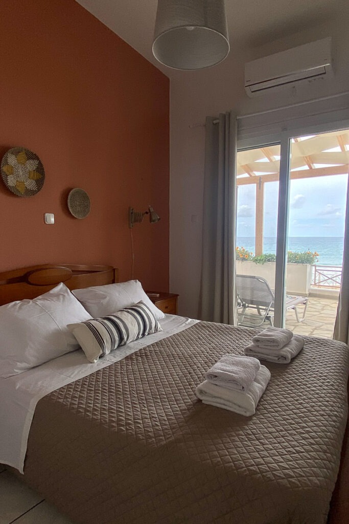 The second bedroom of Galatea 2-bedroom apartment. There's a double bed with grey linen and white towels on top.