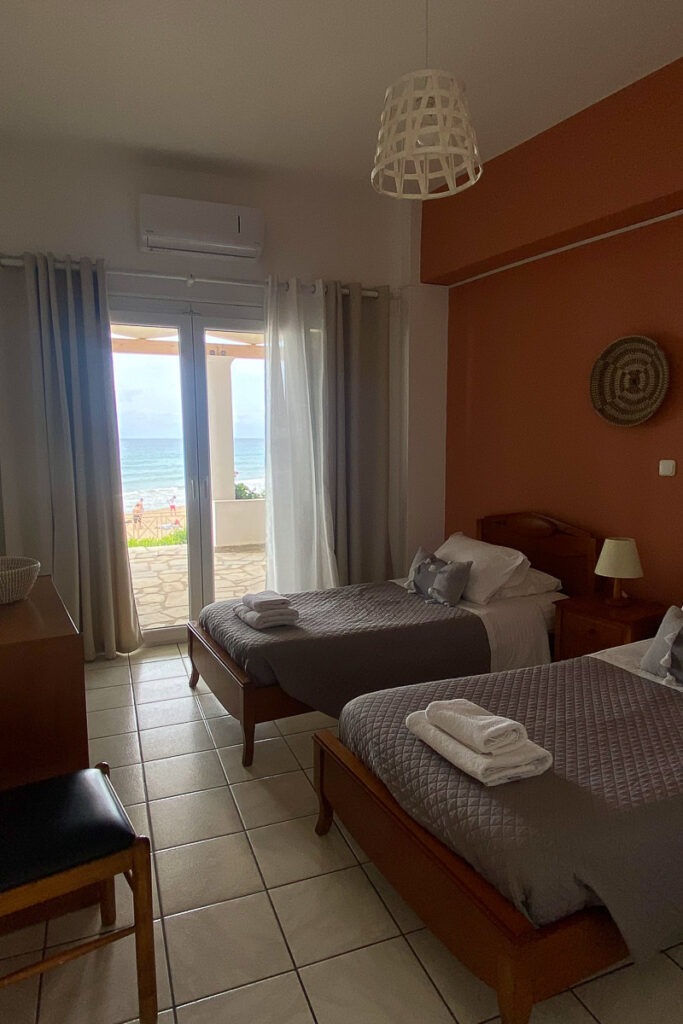 Two single beds in Galatea's bedroom. The beds have grey linen and white towels on top.