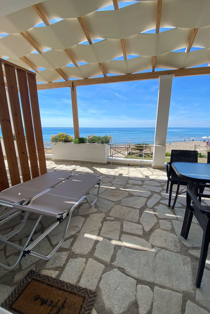 Two sunbeds and a table with chairs at Galatea's terrace.
