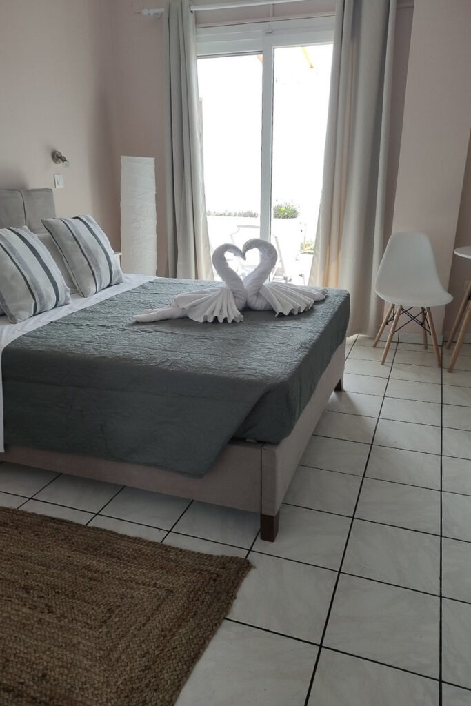 The double bed in Melite studio with two towels on top forming two swans kissing.