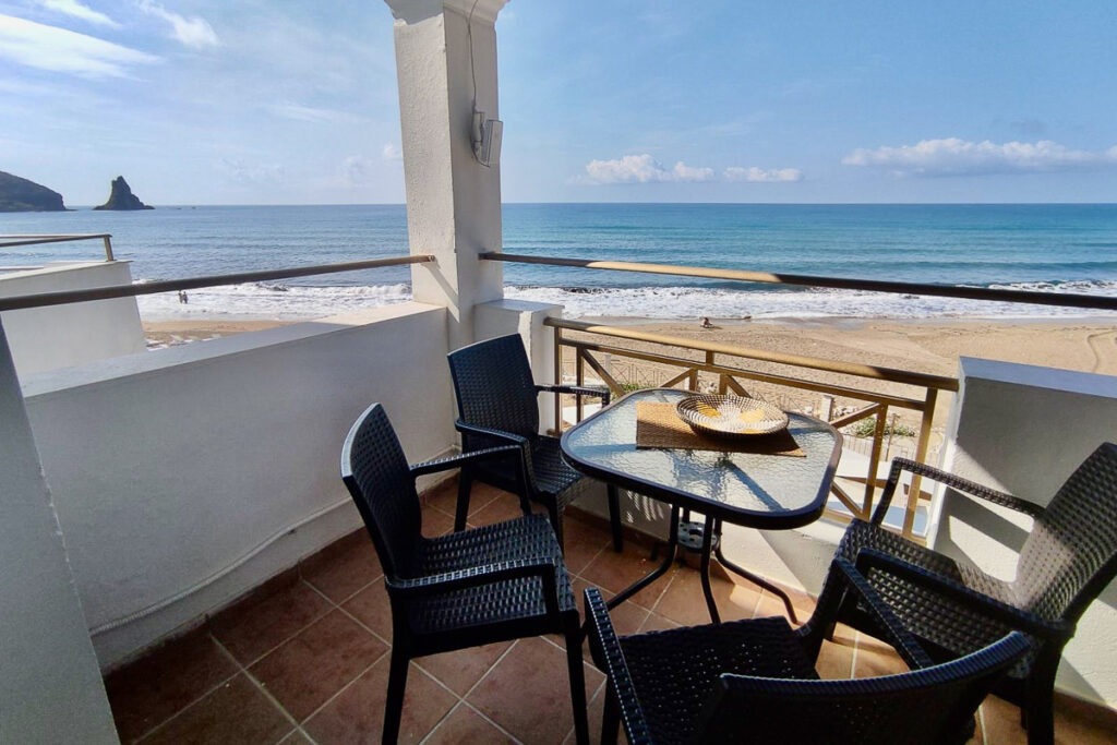 The balcony with a table and four chairs of Pasithea apartment with sea view of Agios Gordios Beach.